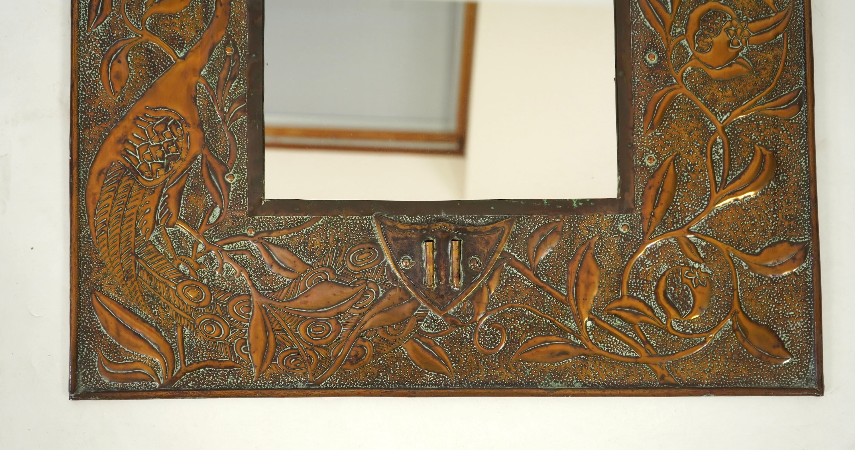 An Arts and Crafts embossed copper mirror, manner of Talwin Morris, Glasgow School
